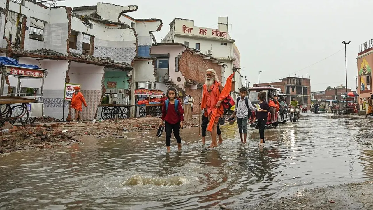 People walk through a waterlogged street leading to the Ram temple in Ayodhya