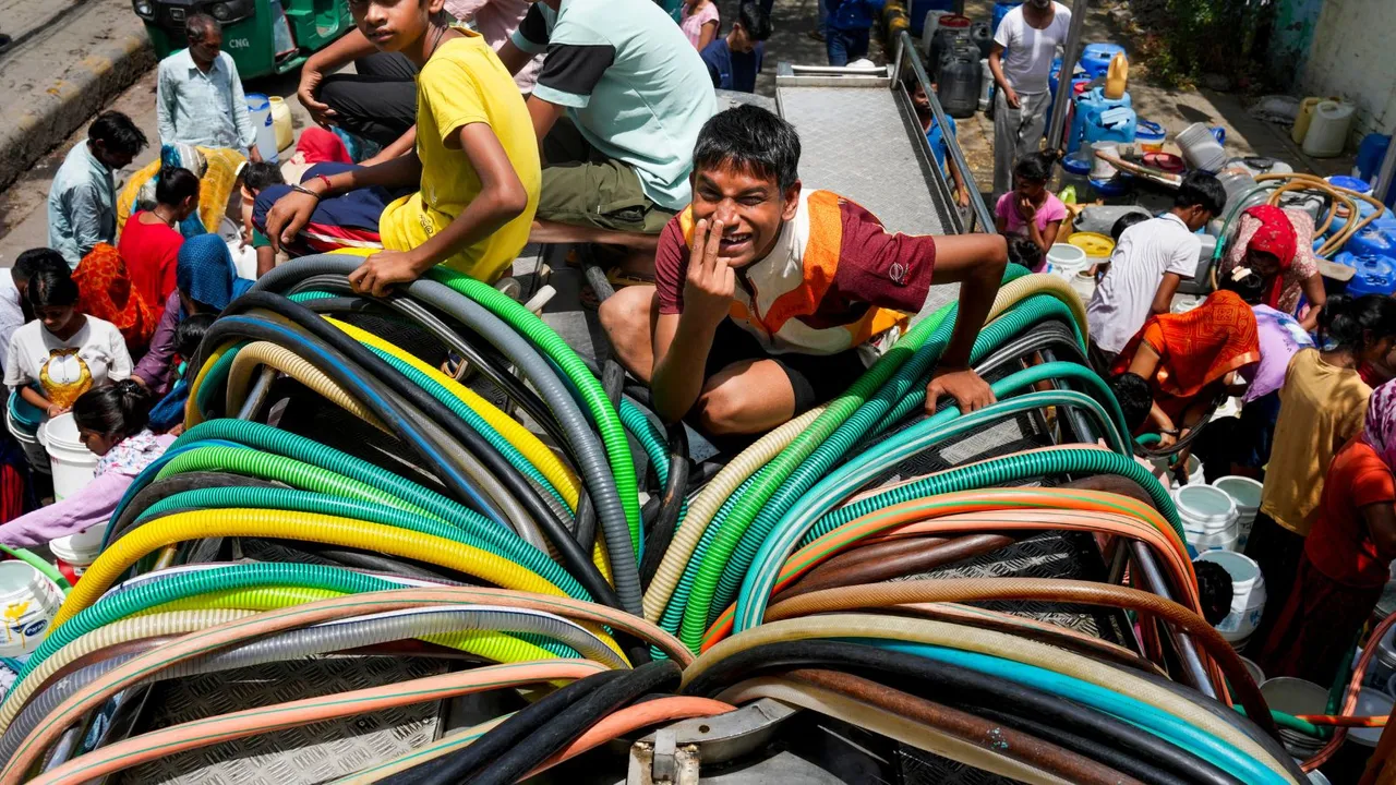 Residents collect drinking water from a tanker amid ongoing water crisis at Vivekananda Colony, Chanakyapuri, in New Delhi, Thursday, May 30, 2024