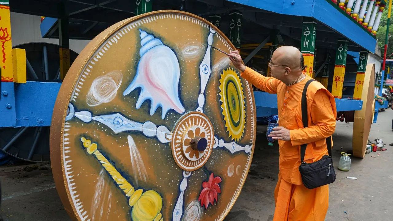 An ISKCON member paints a wheel of Lord Jagannath's chariot ahead of the Rath Yatra festival, in Kolkata
