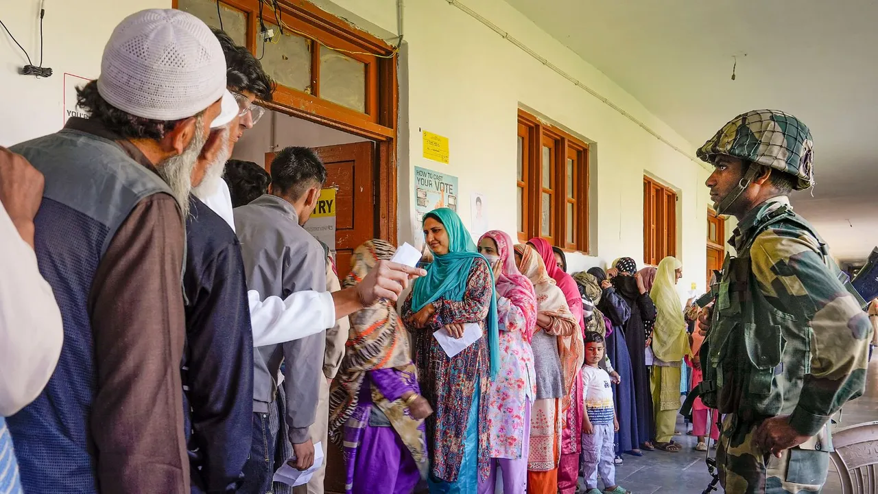 People wait in a queue to cast their votes during the fifth phase of Lok Sabha elections, at a polling booth in Sopore, in Baramulla district, Monday, May 20, 2024