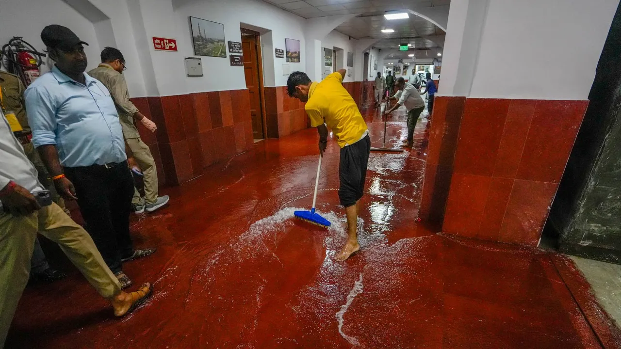 An Uttar Pradesh Legislative Assembly staffer clears rainwater from the flooded premises of the Assembly, in Lucknow, Wednesday, July 31, 2024.