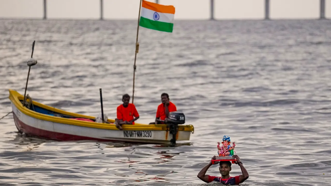 A devotee carries an idol of the Lord Ganesha for immersion in the Arabian Sea amid celebration of the Ganesh Chaturthi festival, in Mumbai