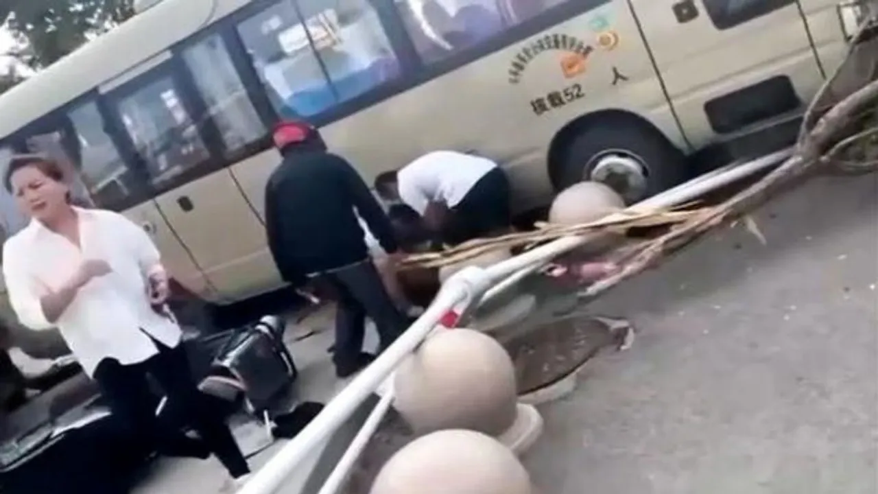 People help someone who was injured when a bus crashed into students and parents outside a school in Tai'an, Shandong Province, China, Sept. 3, 2024