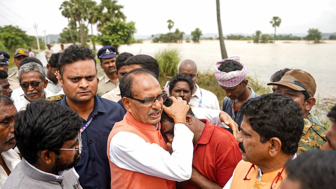 Union Agricultural Minister Shivraj Singh Chouhan consoles an affected person during his visit to the flood affected areas to assess the crop damage, in Kesarapalle, Andhra Pradesh.