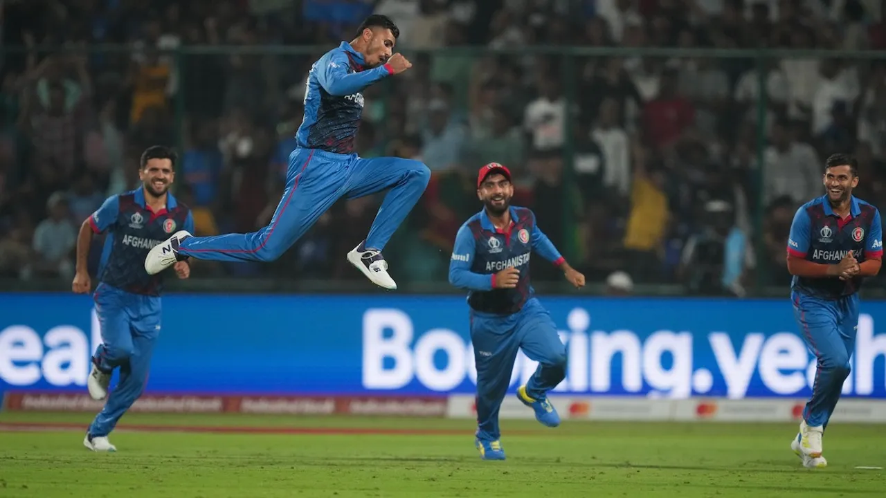 Afghanistan's Mujeeb Ur Rahman with teamamtes celebrates the wicket of England's Chris Woakes during the ICC Men's Cricket World Cup 2023 match between Afghanistan and England, at Arun Jaitley Stadium in New Delhi, Sunday, Oct. 15, 2023.