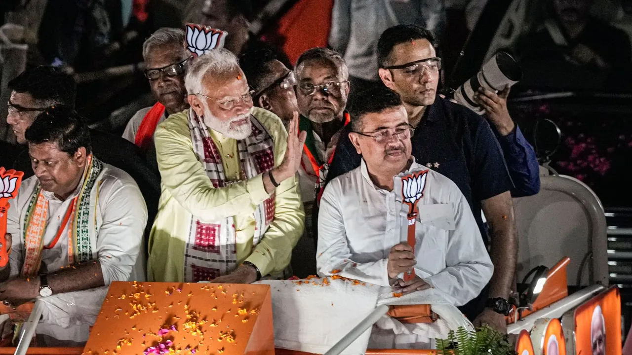 Prime Minister Narendra Modi with West Bengal BJP President Sukanta Majumdar and party leader Suvendu Adhikari during a roadshow for Lok Sabha elections, in Kolkata, Tuesday, May 28, 2024