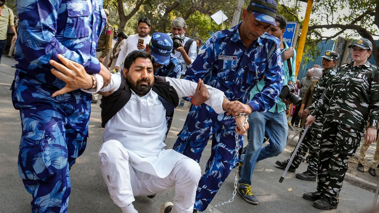 Security personnel detain an AAP supporter during a protest against the arrest of Delhi Deputy Chief Minister Manish Sisodia by CBI in the excise policy case Delhi on Monday