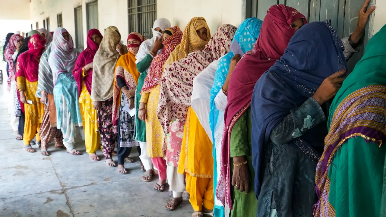 Voters wait in a queue to cast their votes at a polling station at Ghasera village during the Haryana Assembly elections, in Nuh district, Saturday, Oct. 5, 2024.