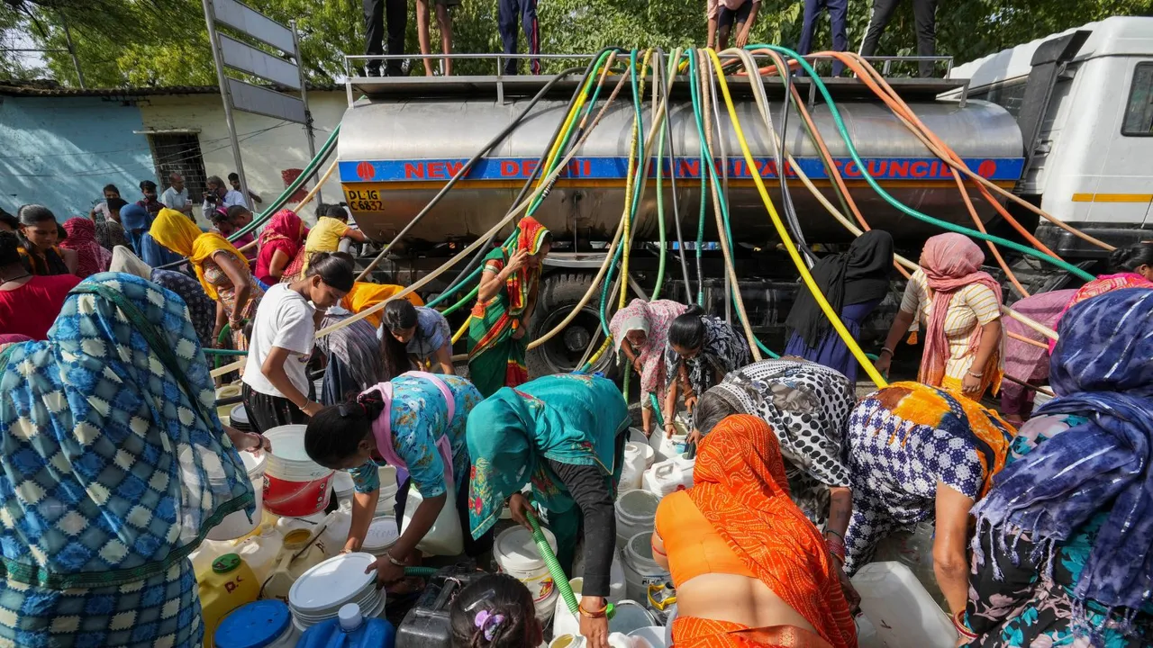 People collect drinking water from a tanker amid ongoing Delhi water crisis, at Vivekanand camp in New Delhi, Thursday, June 13, 2024.