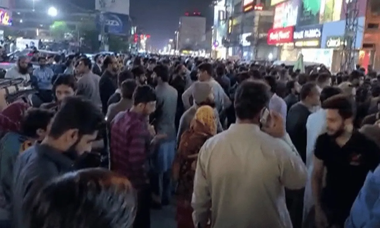 People in Lahore come out of their homes after strong tremors were felt on Tuesday night