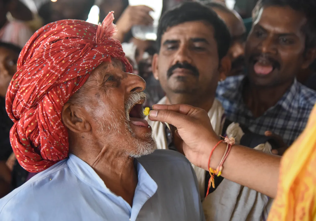 A member of the Bathini family administers traditional fish 'prasadam' to an asthma patient at the Nampally Exhibition ground in Hyderabad