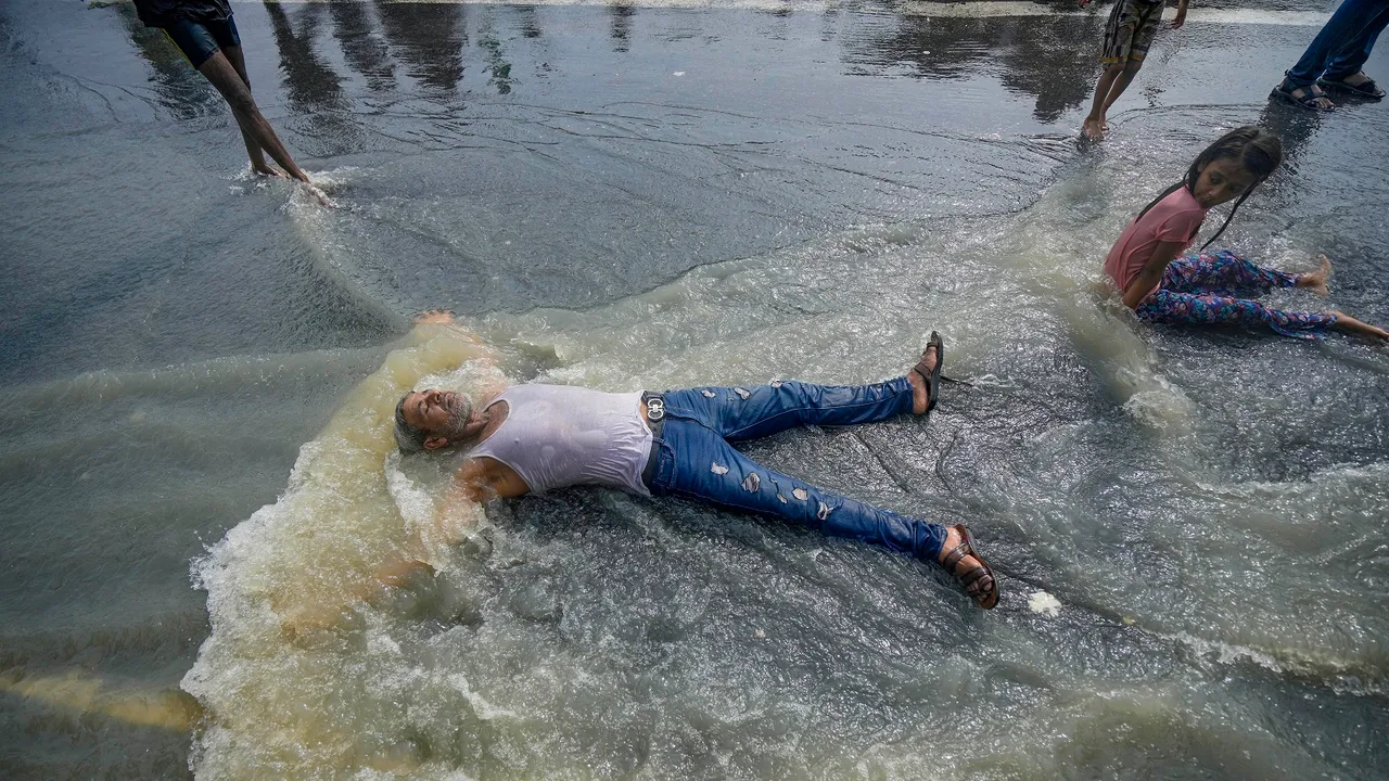 Locals take bath in floodwaters of the swollen Yamuna river at Raj Ghat, in New Delhi
