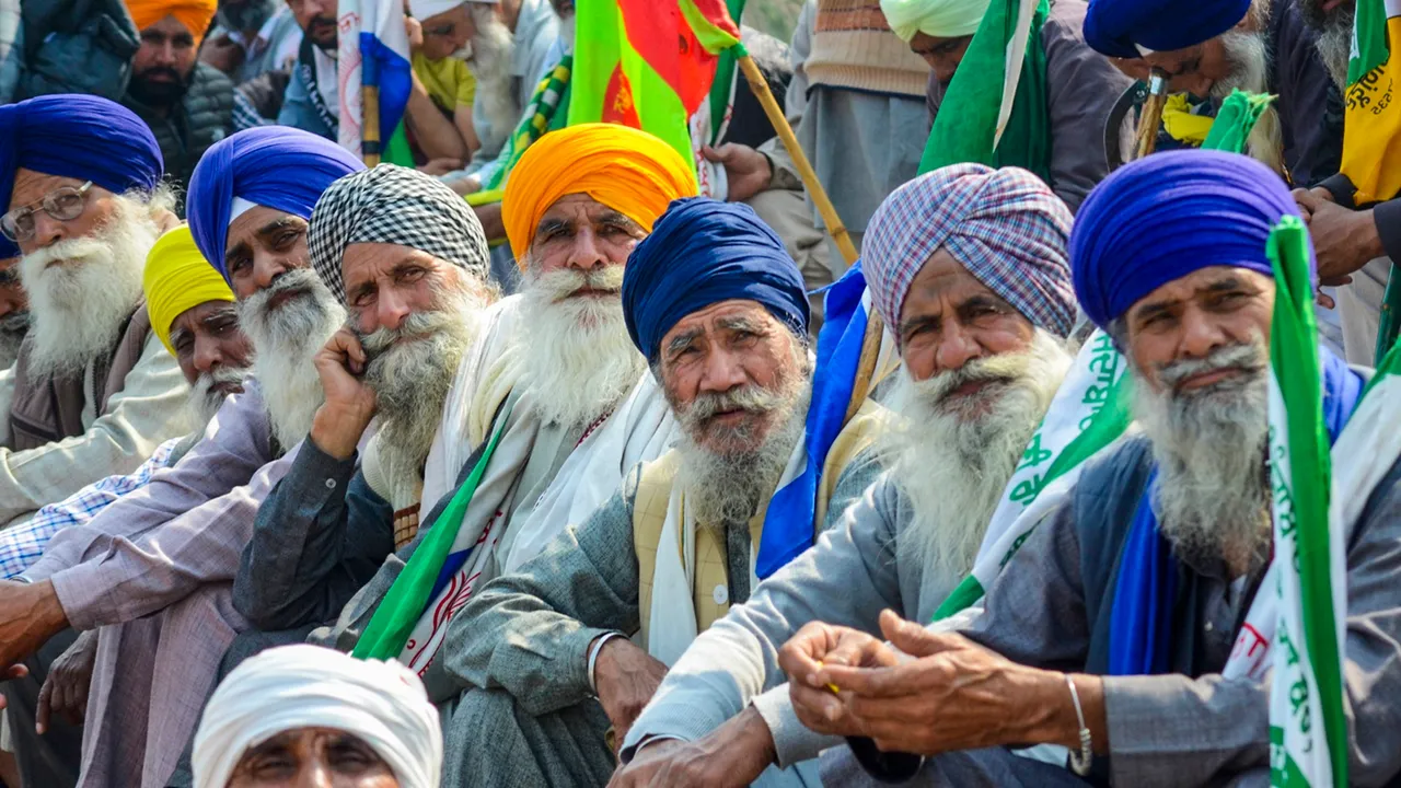 Farmers listen to a leader (unseen) at the Punjab-Haryana Shambhu border during farmers' 'Delhi Chalo' protest, near Patiala district