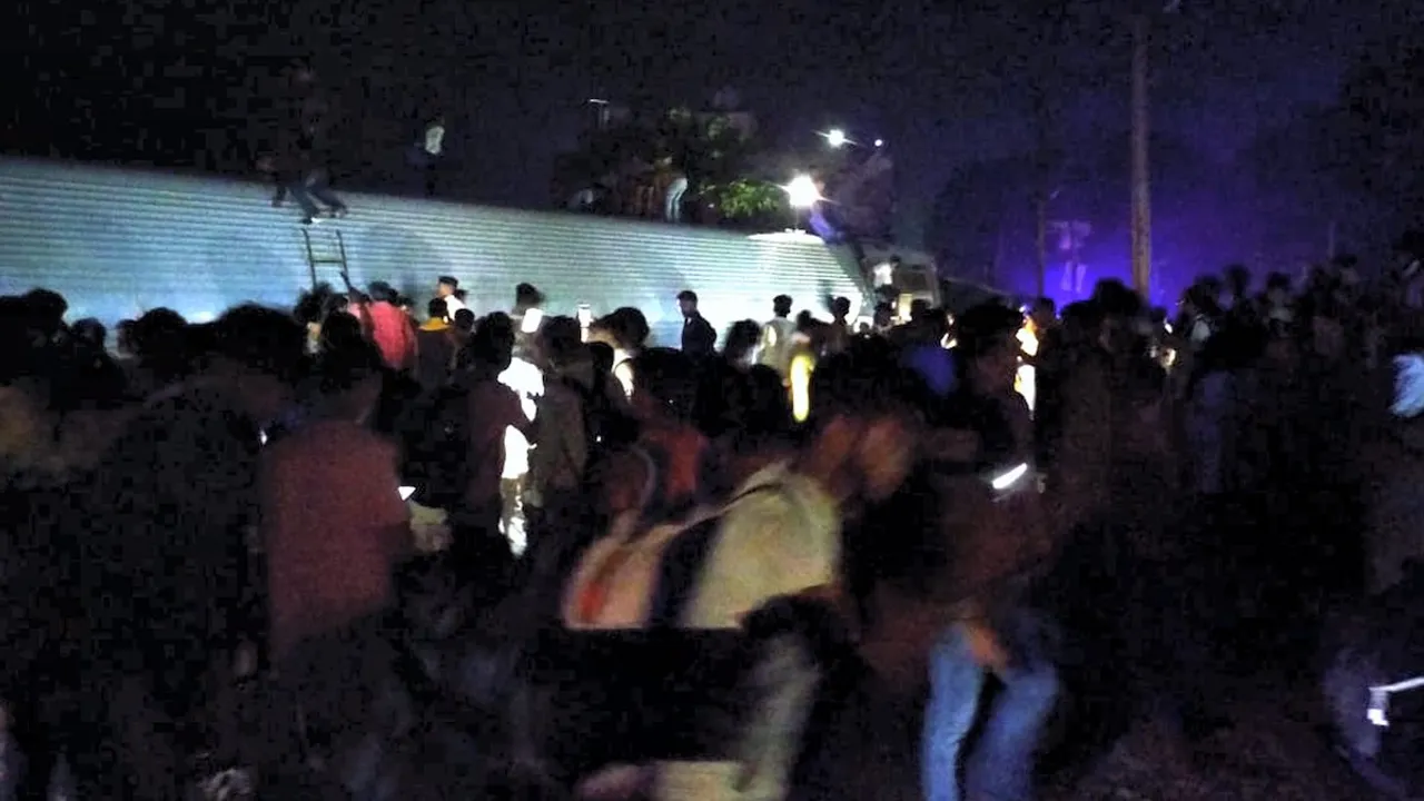 Passengers and locals at the site of the accident after three bogies of North East Express derailed near Raghunathpur railway station in Buxar district, Wednesday evening, Oct. 11, 2023.