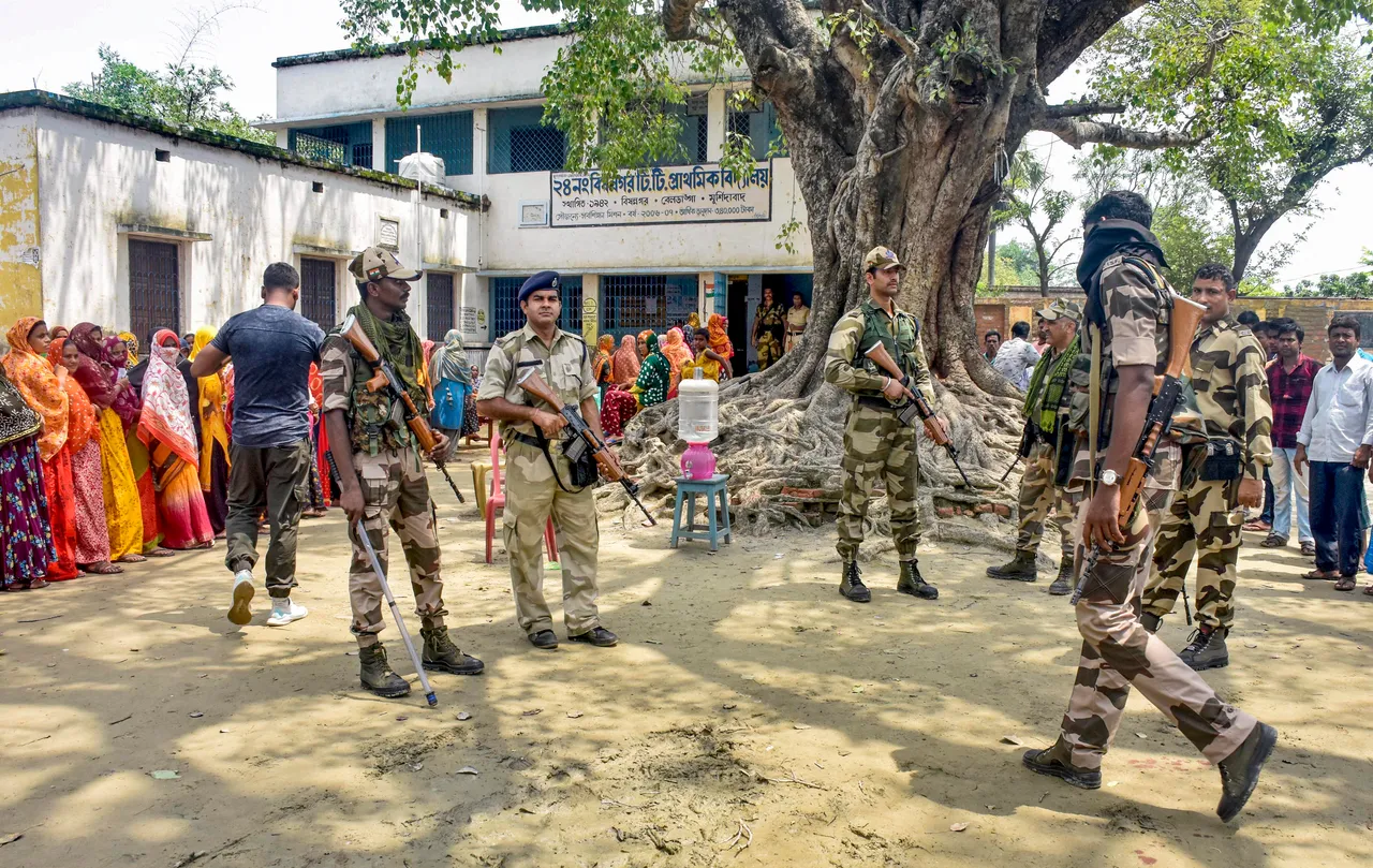Security personnel stand guard at a polling booth during Panchayat repolls, in Murshidabad district