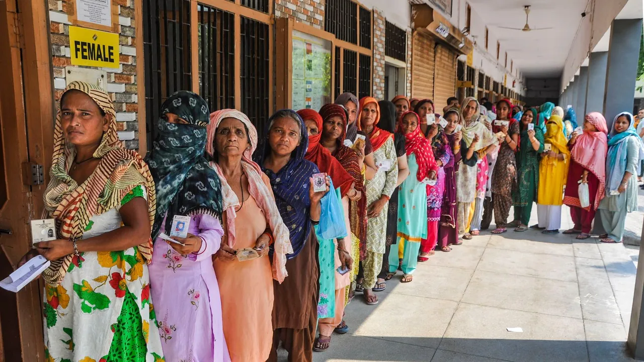 People wait in a queue to cast their votes at a polling booth during the sixth phase of Lok Sabha elections, in Sonipat, Saturday, May 25, 2024