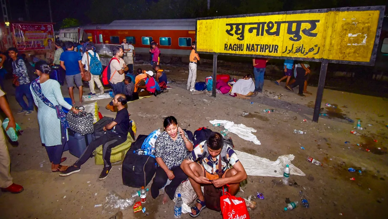 Passengers wait at the Raghunathpur railway station after multiple coaches of the Delhi-Kamakhya North East Express derailed, in Buxar district