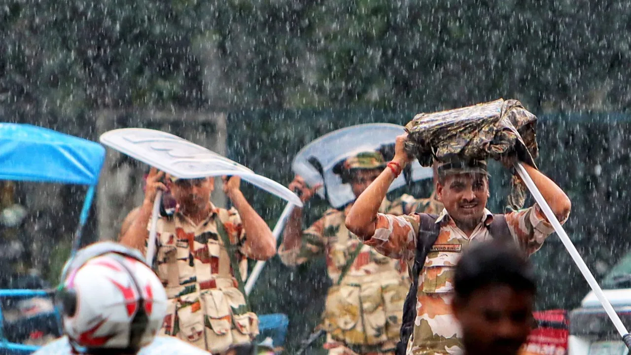 Security personnel shield themselves from rainwater, in New Delhi, Sunday, Aug. 11, 2024.