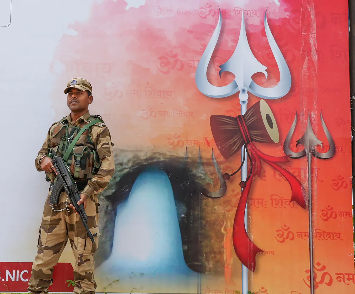 A security personnel stands guard at Yatri Niwas base camp ahead of the commencement of the Amarnath Yatra 2023, in Jammu.jpg