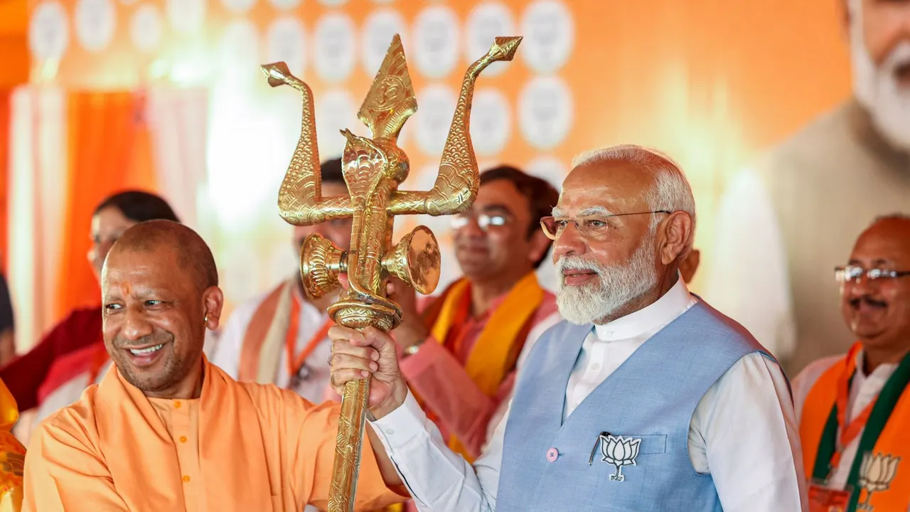 Prime Minister Narendra Modi being presented a trident by Uttar Pradesh Chief Minister Yogi Adityanath during a public meeting for Lok Sabha elections, in Barabanki, Uttar Pradesh, Friday, May 17, 2024
