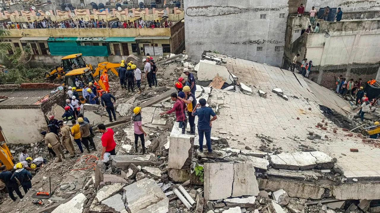 Officials and others during a rescue operation after a building collapse, in Surat district, Saturday, July 6, 2024.