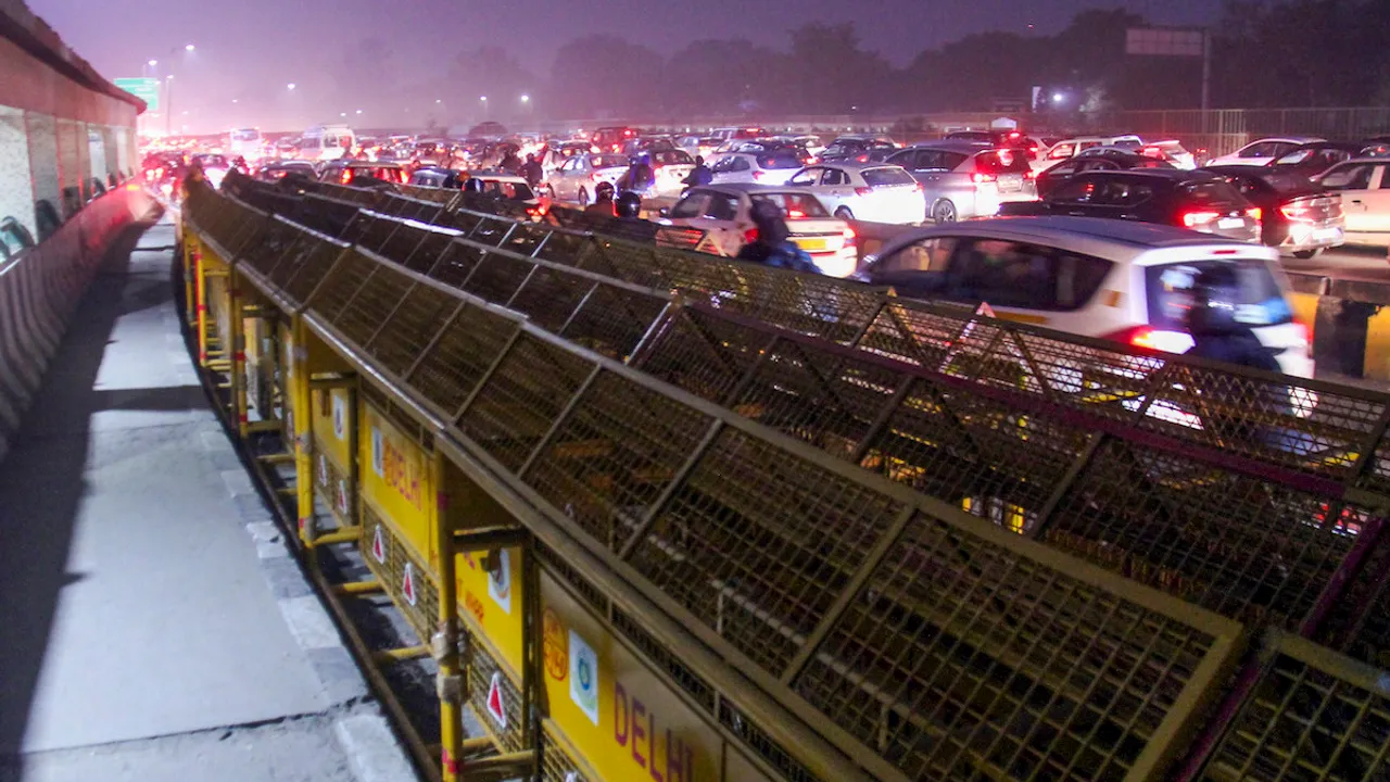 Vehicles move past police barricades during a traffic jam at the Delhi-Gurugram border near Sirhaul Toll Plaza ahead of scheduled march by the protesting farmers, in Gurugram, Monday, Feb. 12, 2024.