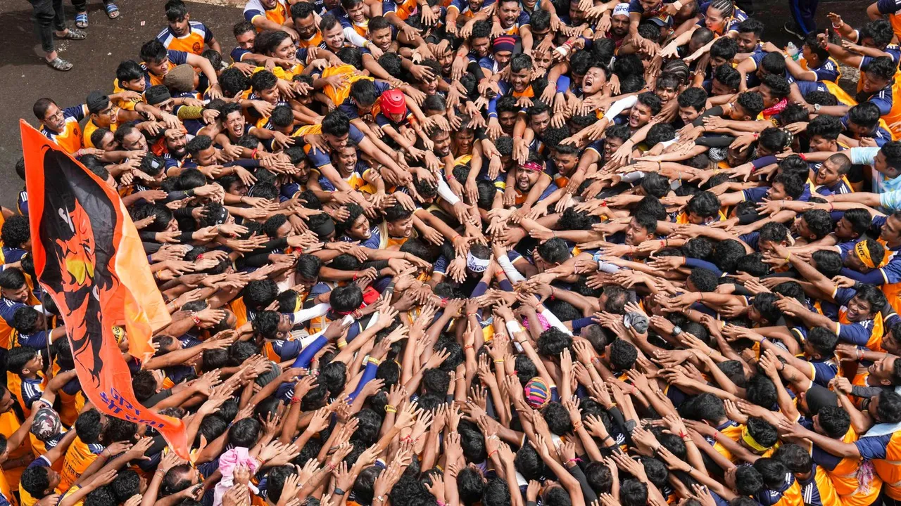 Devotees gather to form a human pyramid to break the 'dahi handi', an earthen pot filled with curd, as part of 'Janmashtami' festival celebrations, at Dadar in Mumbai, Tuesday, Aug. 27, 2024.