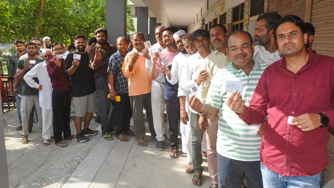 Voters wait in a queue to cast their votes at a polling station during the Haryana Assembly elections, in Sonipat, Saturday, Oct. 5, 2024