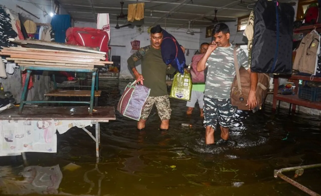 CRPFs 171 battalion jawans shift with their belongings from a flooded area, in Dibrugarh