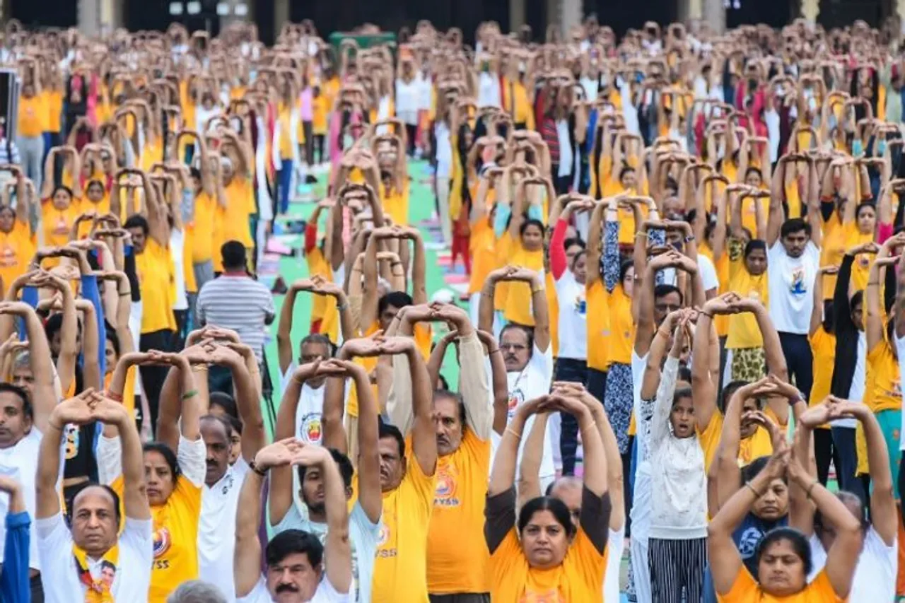 People perform yoga asanas during a yoga programme, for rehearsal ahead of the International Day of Yoga, at Mysore Palace