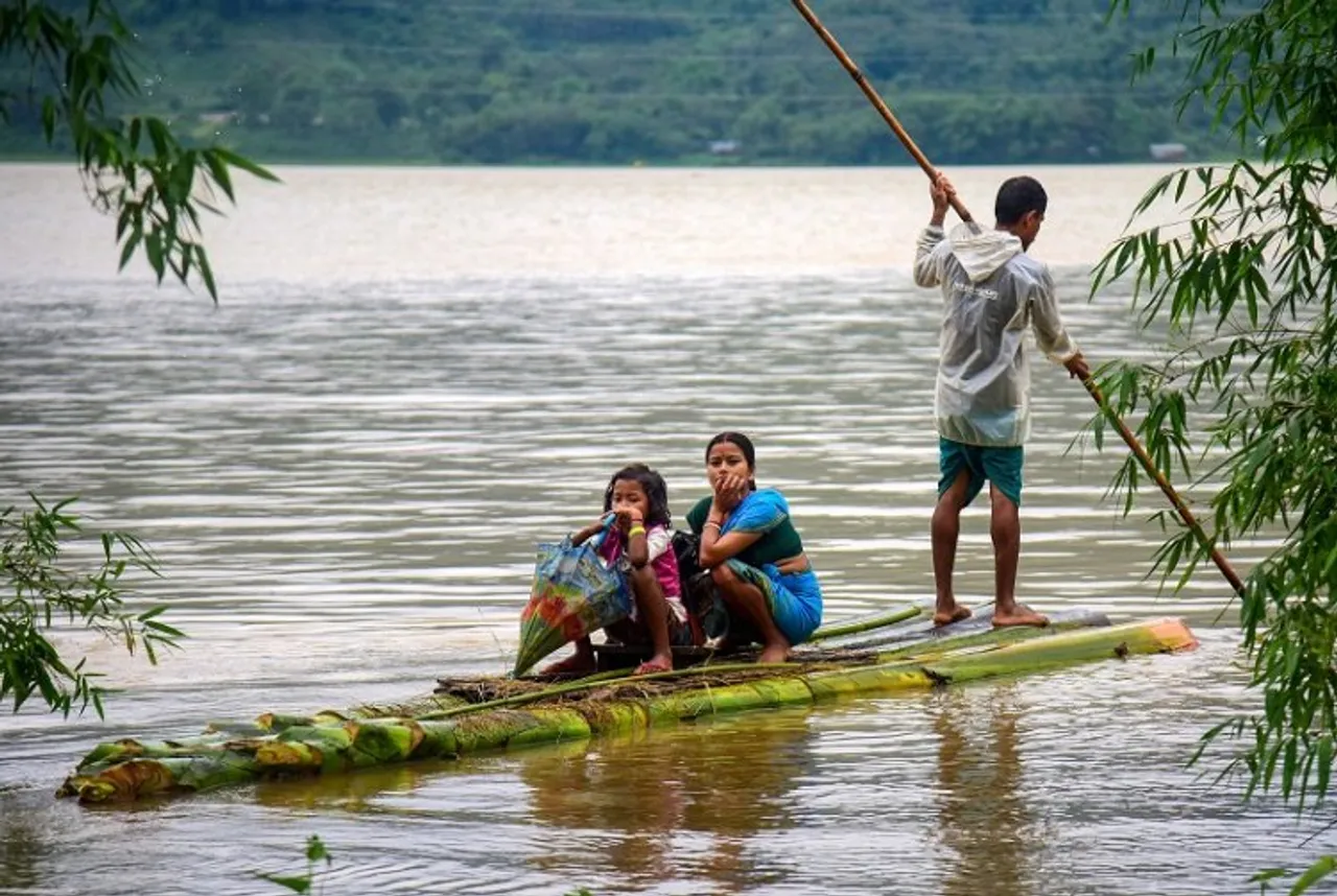 Villagers use a makeshift boat to move to a safer place from a flood-affected area following heavy rainfall 