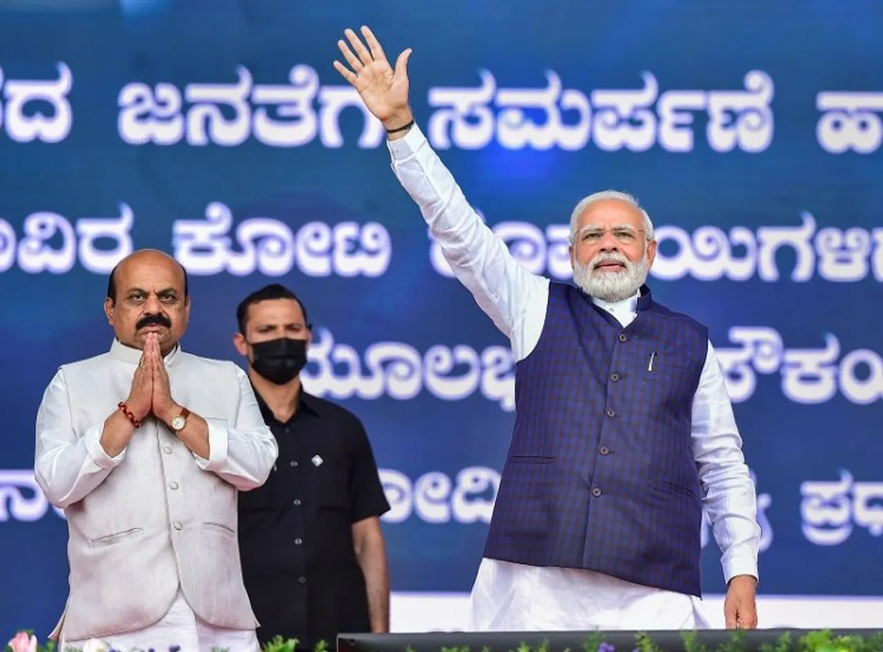 Prime Minister Narendra Modi waves towards supporters during the launch of railway and road projects, in Bengaluru