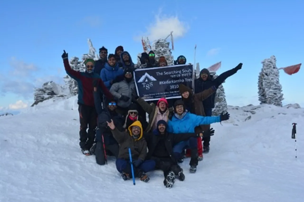 A trekker overlooking the Himalayan range with a map and digital planning interface