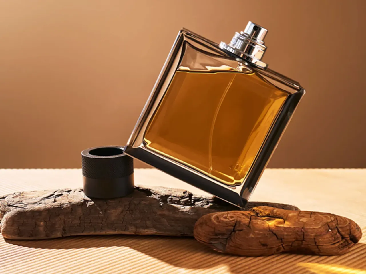 Alt text: Oud chips, frankincense tears, sandalwood logs, and vetiver roots displayed together for a men’s perfume feature.