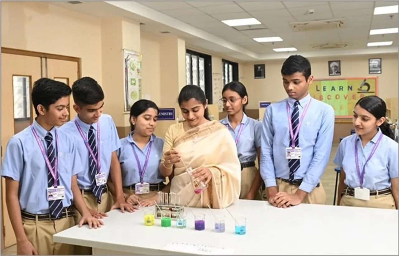 Podar International School, Veraval students performing a science experiment in a modern, well-equipped lab.