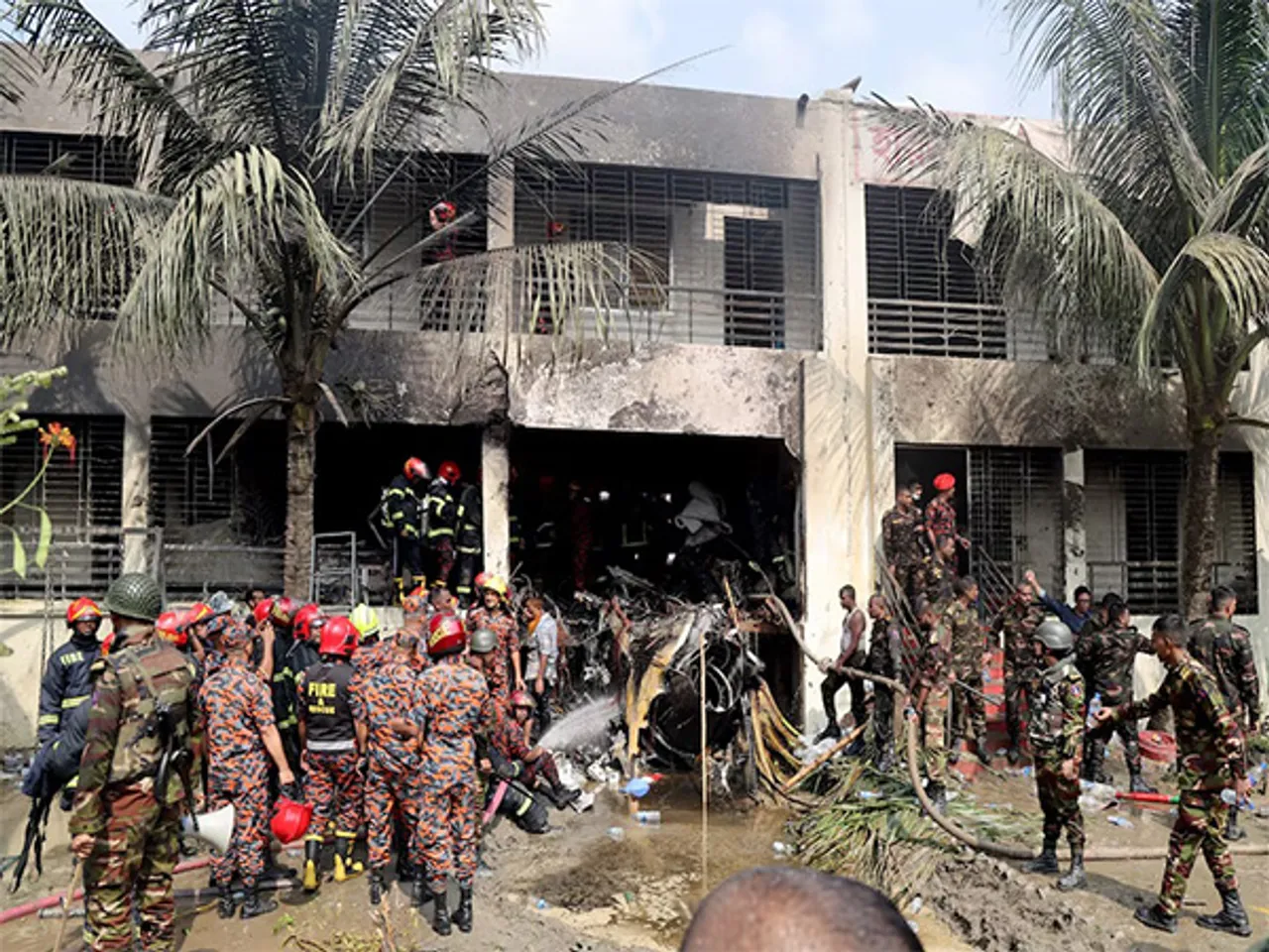 Firefighters and soldiers at the crash site of a Bangladesh Air Force training jet in Dhaka (Photo/Reuters)