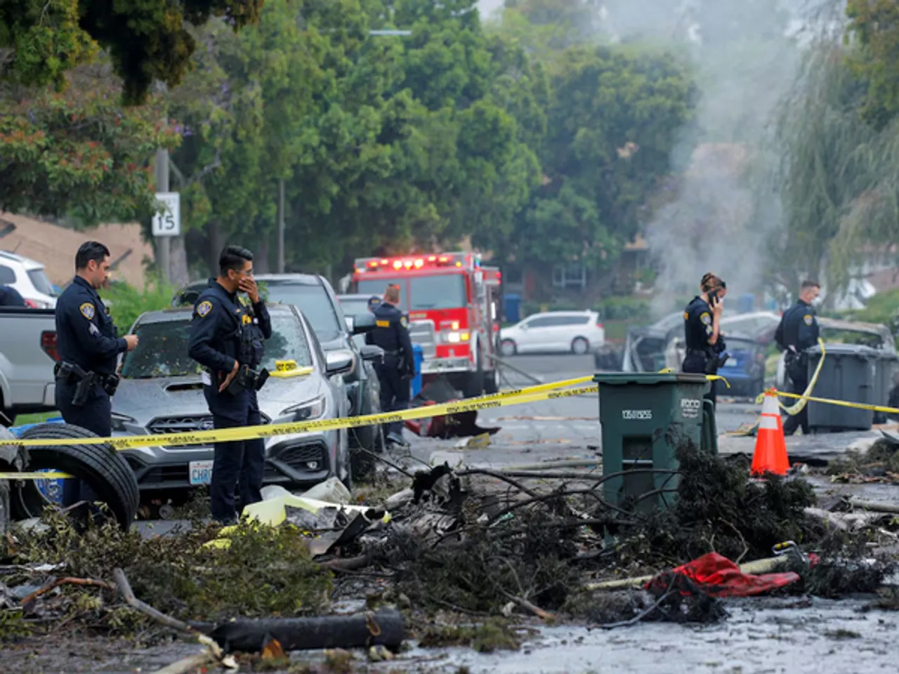 Emergency personnel work at the crash scene on a street, after a small civilian aircraft went down in a military neighborhood in San Diego (Image/Reuters)