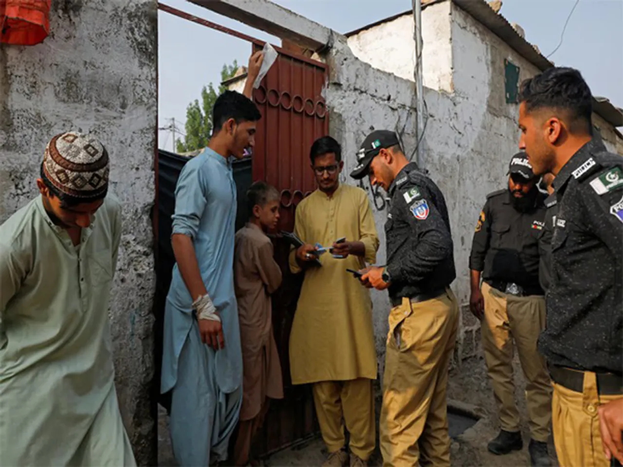 Police and NADRA officials verify Afghan nationals’ IDs during a door-to-door drive at a refugee camp in Karachi, Pakistan (File Photo/Reuters)