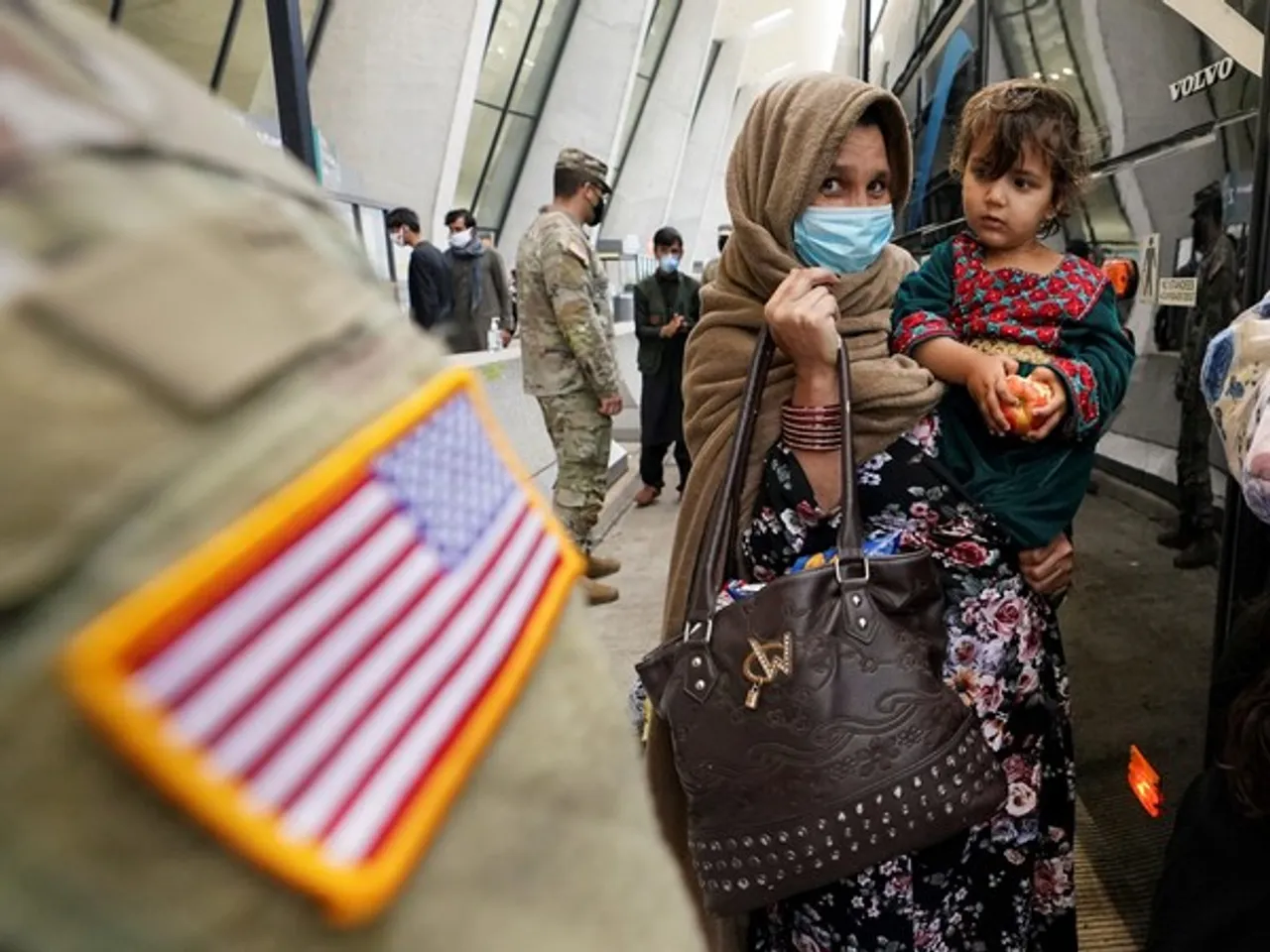 Afghan refugees board a bus to a processing center upon arrival at Dulles International Airport in Virginia, a day after US forces completed their troop withdrawal from Afghanistan, on September 1, 2021 (File Photo/Reuters)