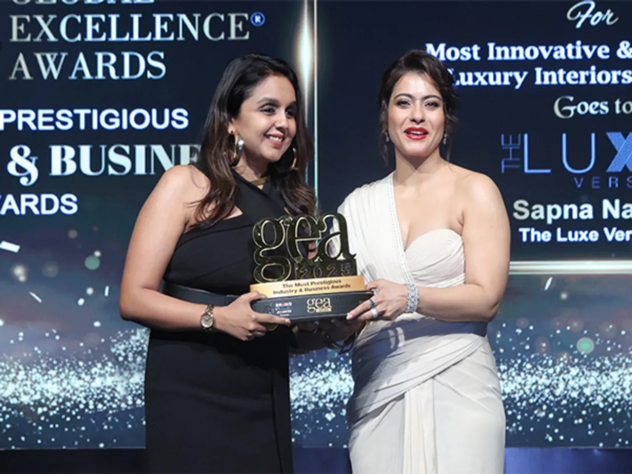 On stage at the Global Excellence Awards 2025, Mrs. Sapna Navin, Founder & CEO of THE LUXE VERSION, celebrates her big win, honoured by Mrs. Kajol Devgan