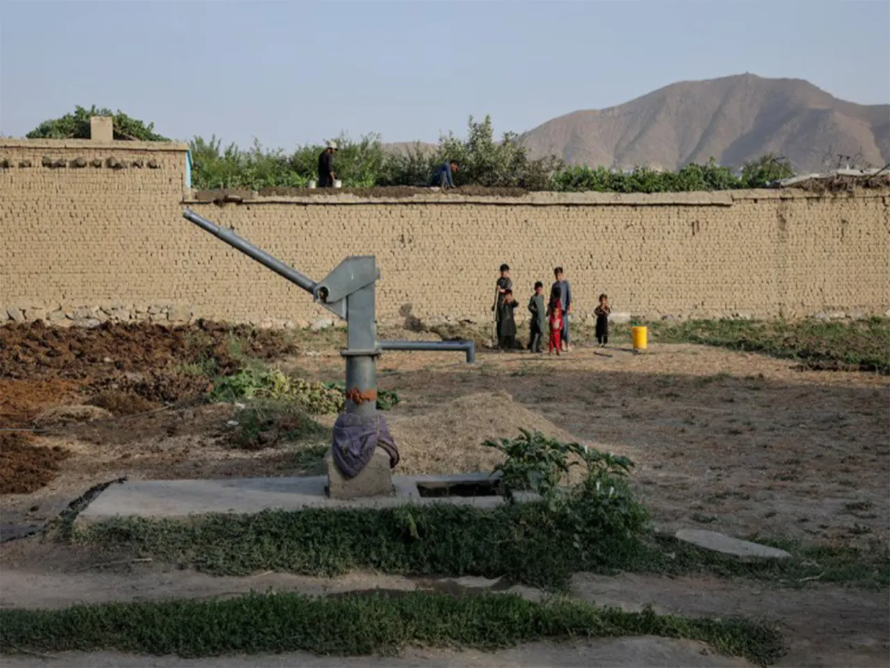Children stand beside a dried-up hand pump amid a worsening water crisis in Kabul, Afghanistan. (File Photo/Reuters)