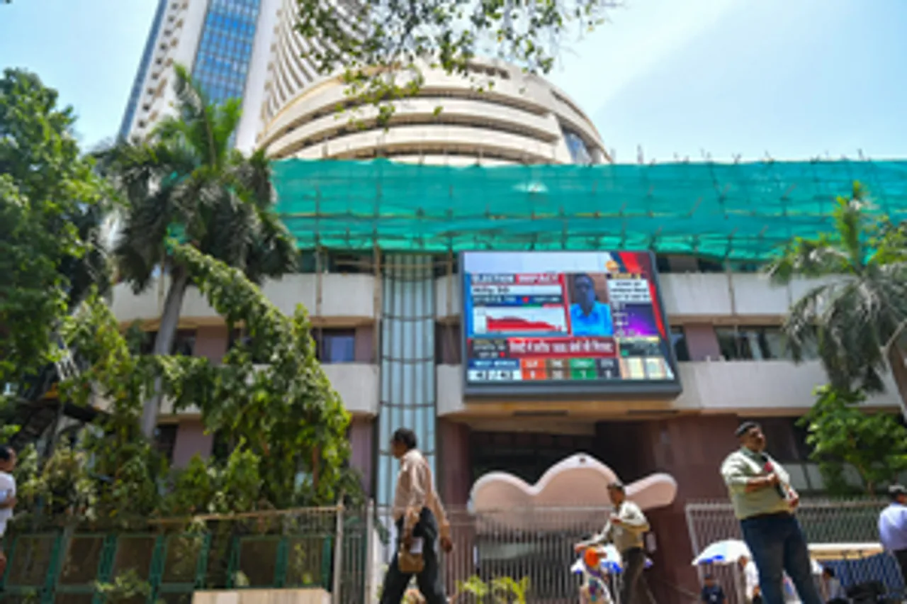 Mumbai: People walk past a screen showing stock market goes down outside BSE building at Dalal Street after the counting of votes for Lok Sabha polls