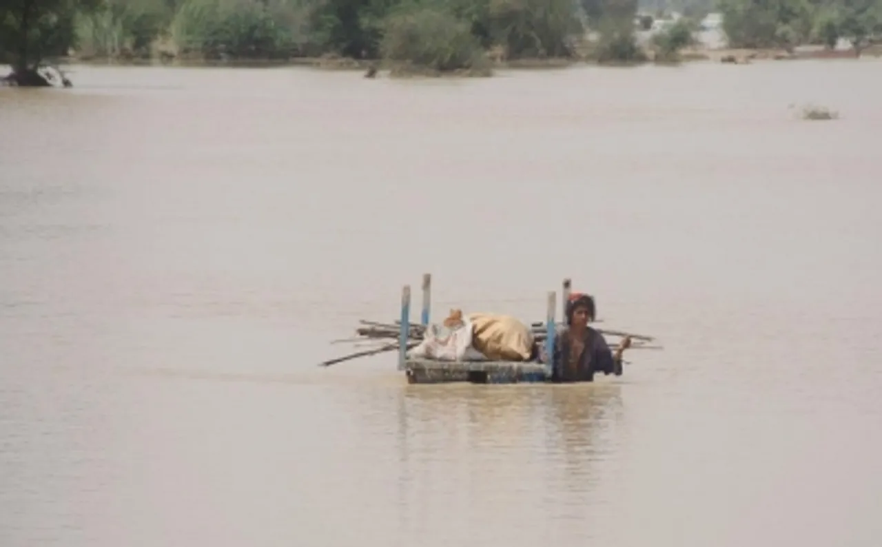 woman with her belongings wades,flood-affected people,Pakistan,Rajanpur district,flood,Houses are damaged,flood-hit house,