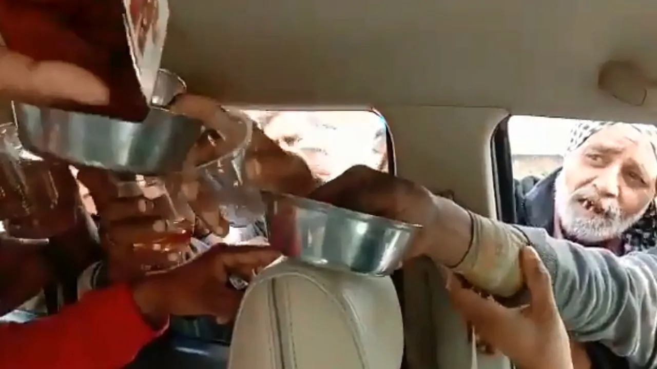 लोगों को शराब बांटता हुआ शख्स