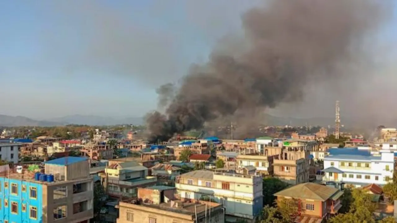 Smoke billows from a fire that broke out amid clashes between armed groups and security forces