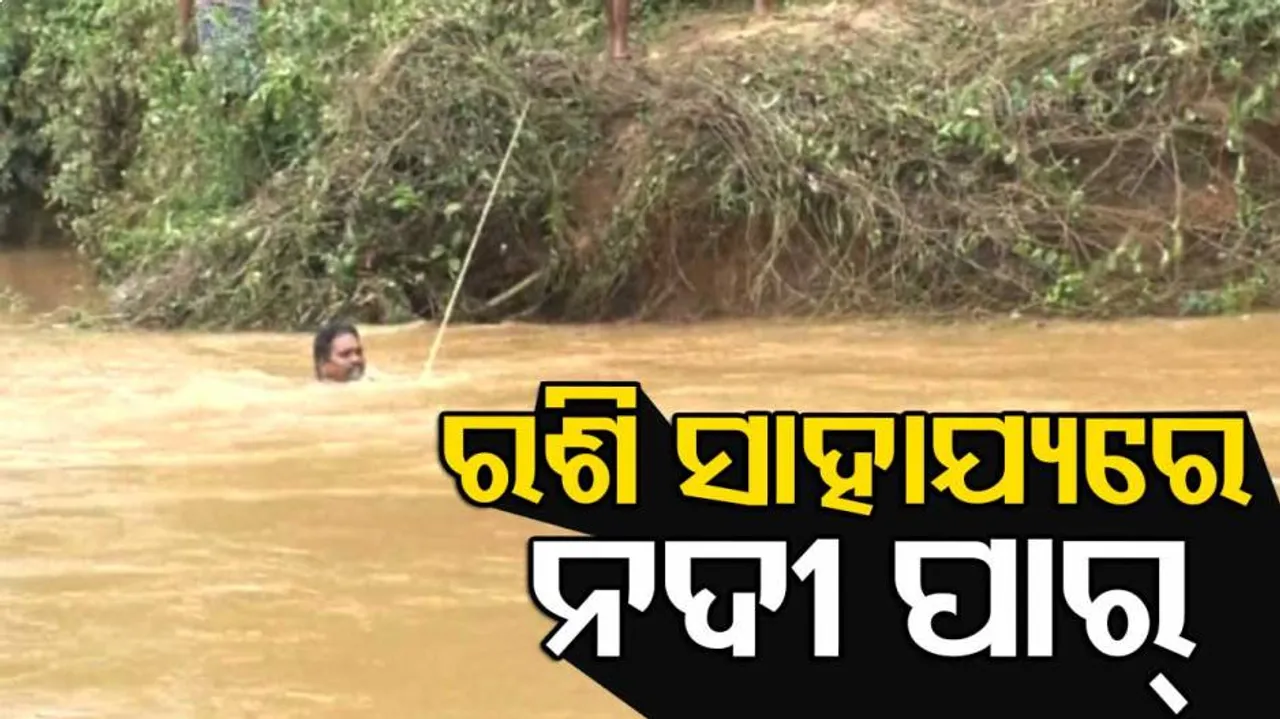 Villagers Hang On To A Rope To Cross River