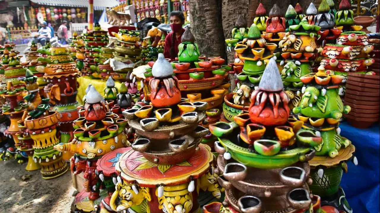 A roadside vendor waits for customers to buy designer earthen lamps ahead of the Diwali festival in 