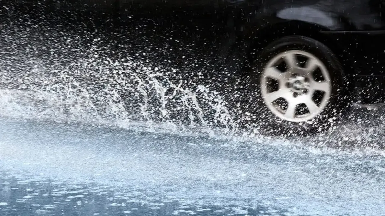 Car Wading Through A Puddle Of Water On Road
