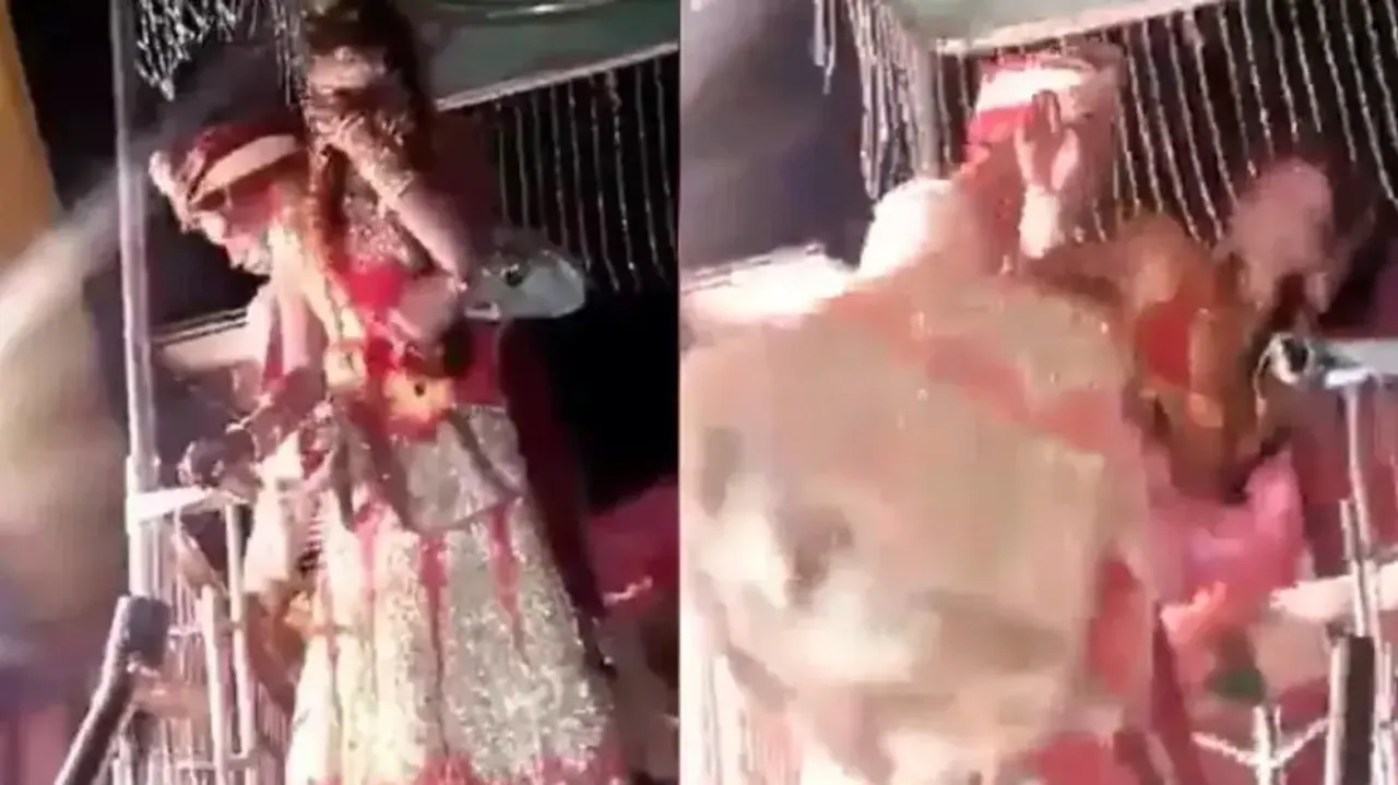 Groom falls with bride while trying to lift her in his arm on wedding stage,