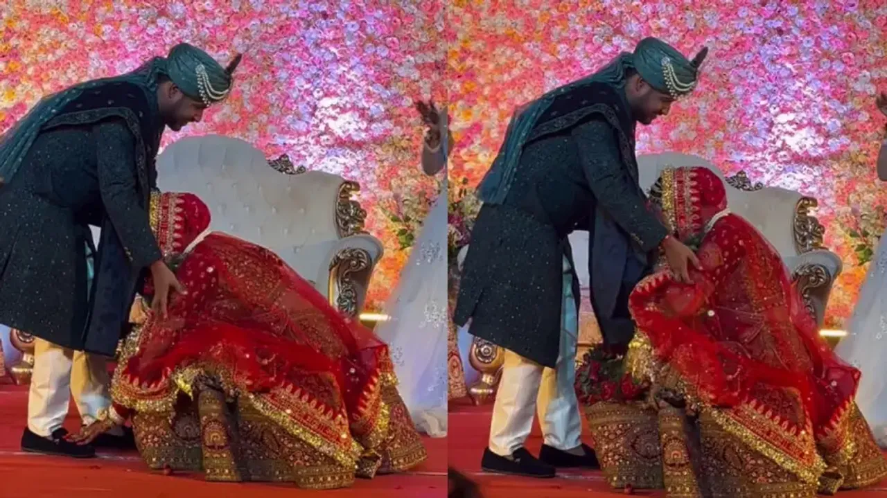 Bride touches groom's feet during varmala ceremony